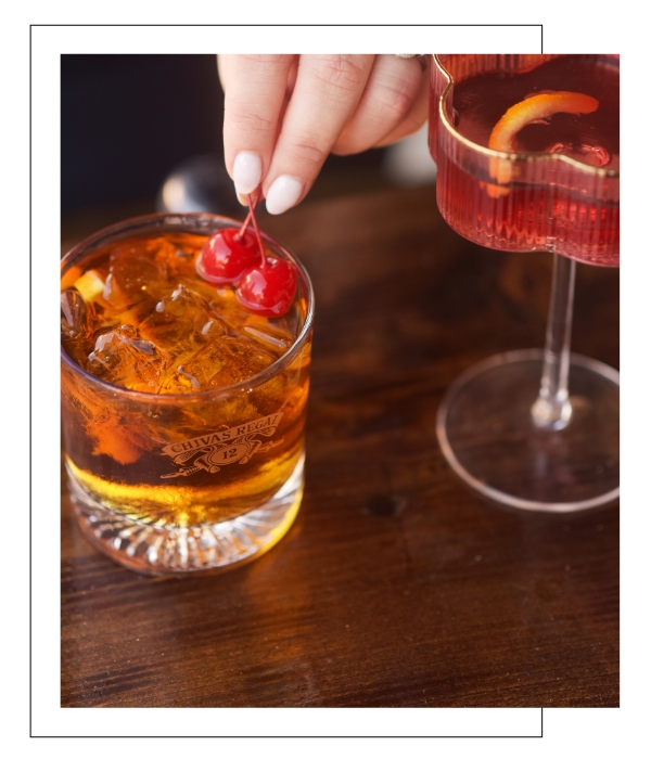 bartending placing cherry garnish on cocktail