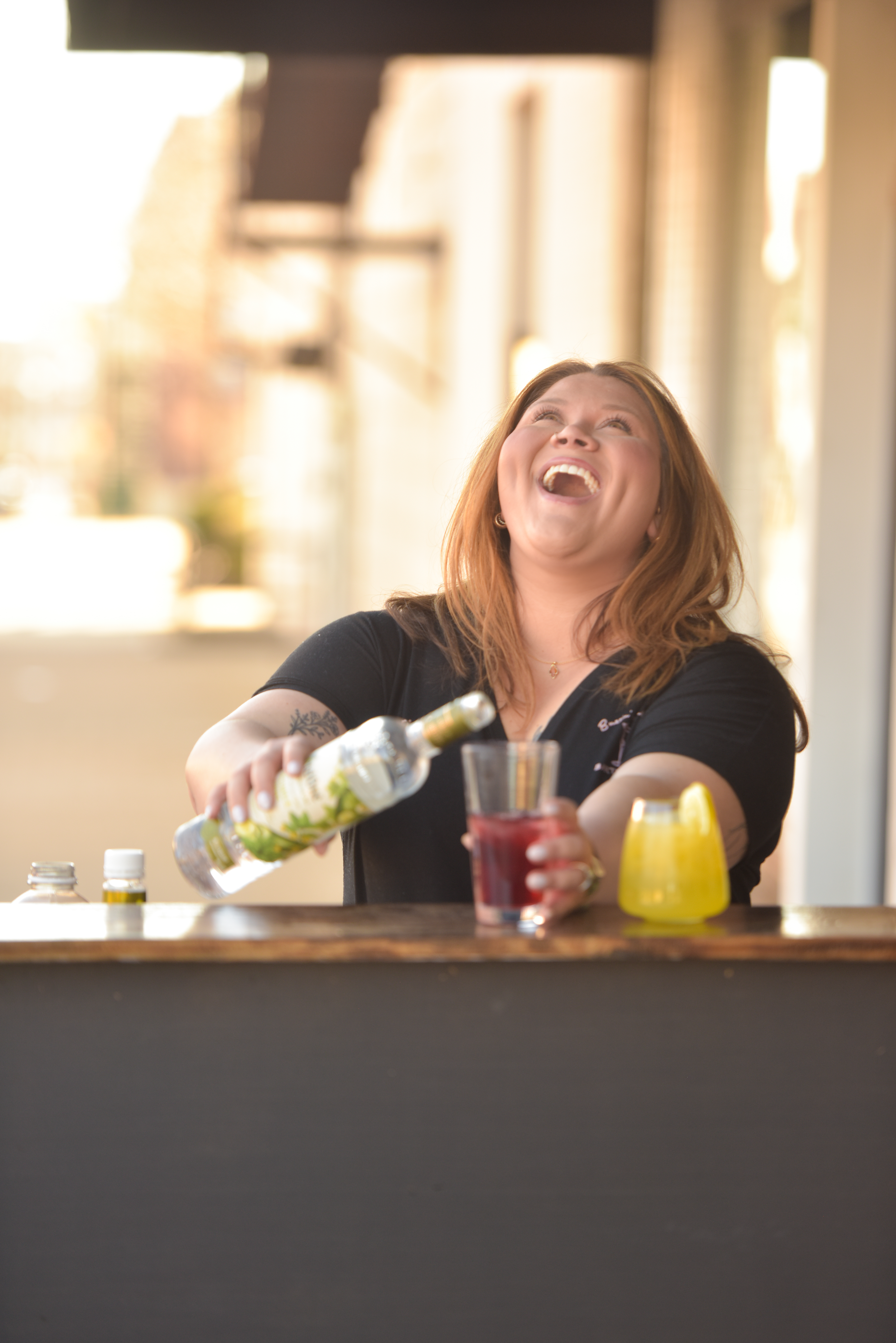 bartender laughing while mixing drink